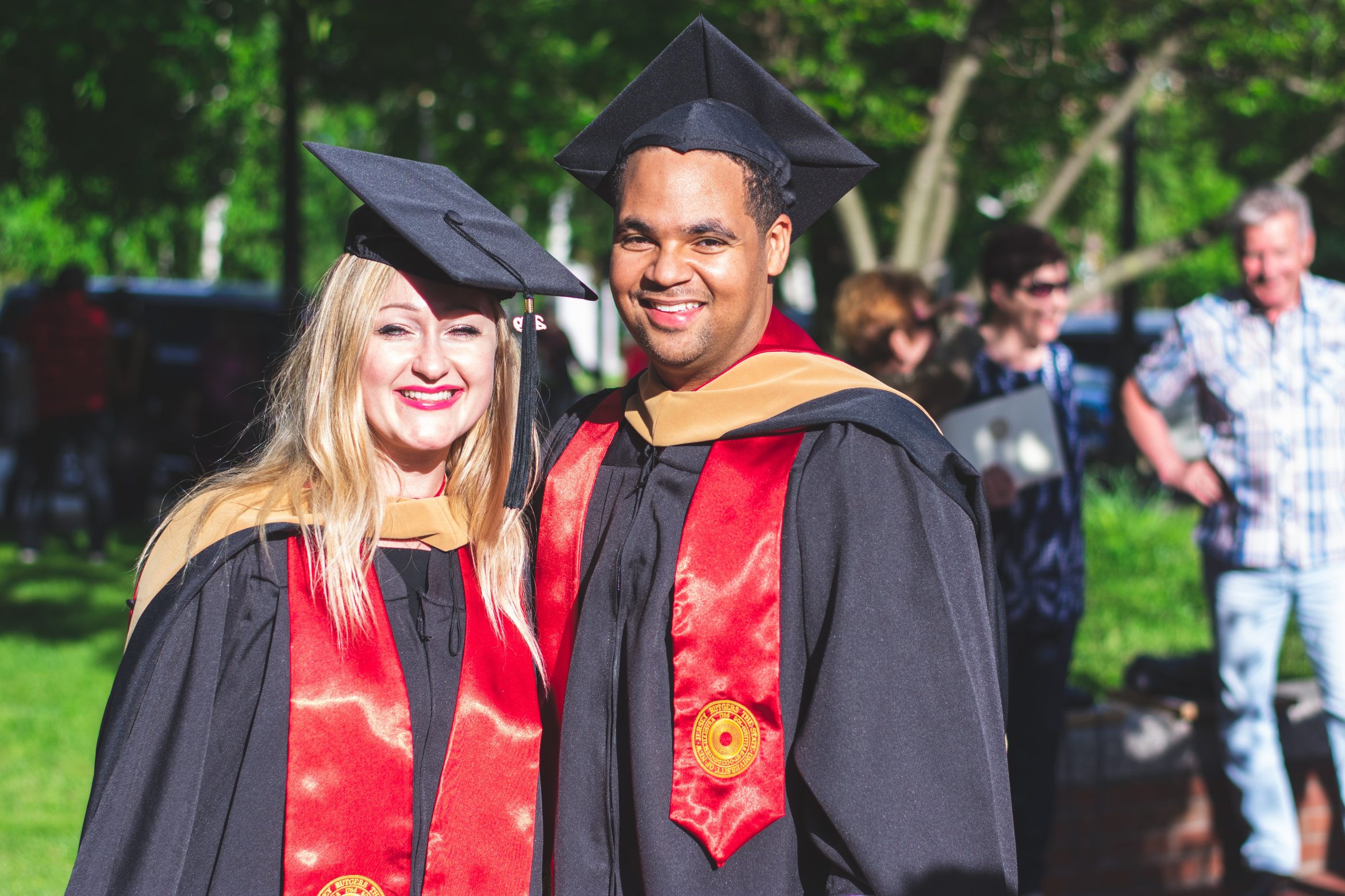 man-and-woman-in-black-and-red-toga-gown-standing-side-by-2365532